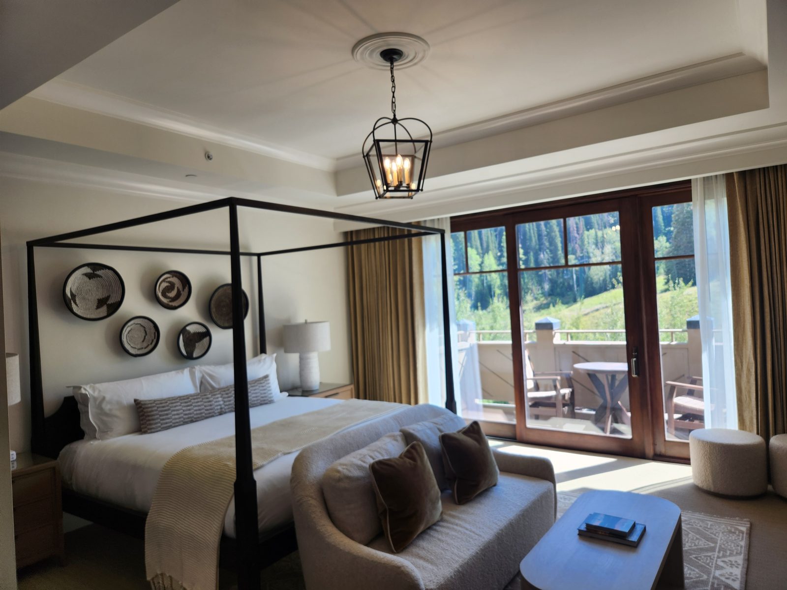 Primary bedroom finished in warm neutrals with a four-poster bed